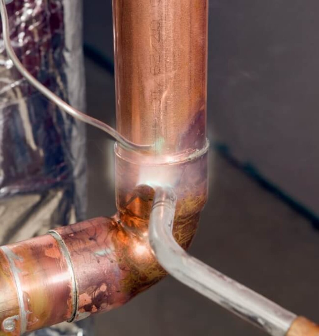 Beim Hartlöten wird eine Verbindung an einer Kupferrohrleitung erhitzt und geschlossen.