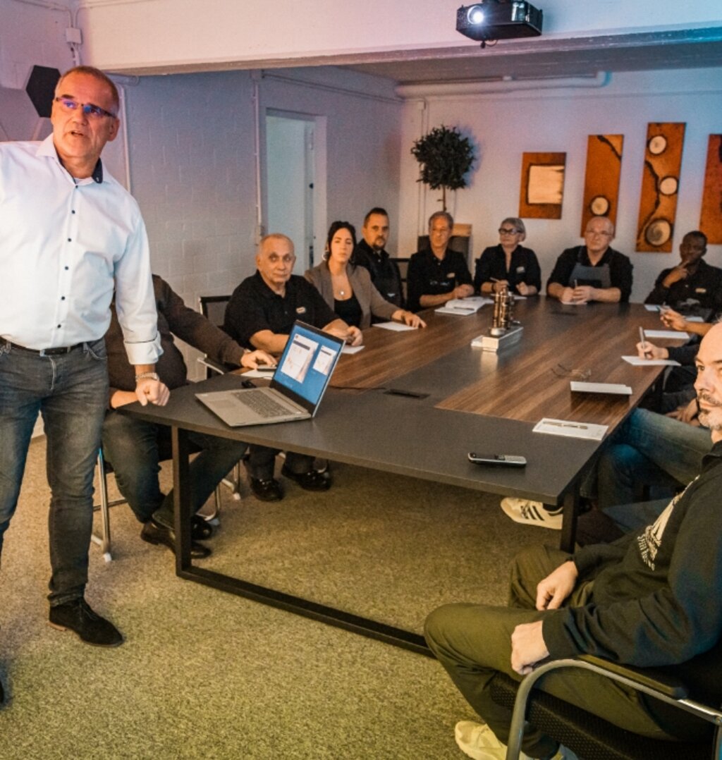 Dozent erklärt technischen Inhalt vor einer Gruppe von Teilnehmern in einer Inhouse-Schulung.