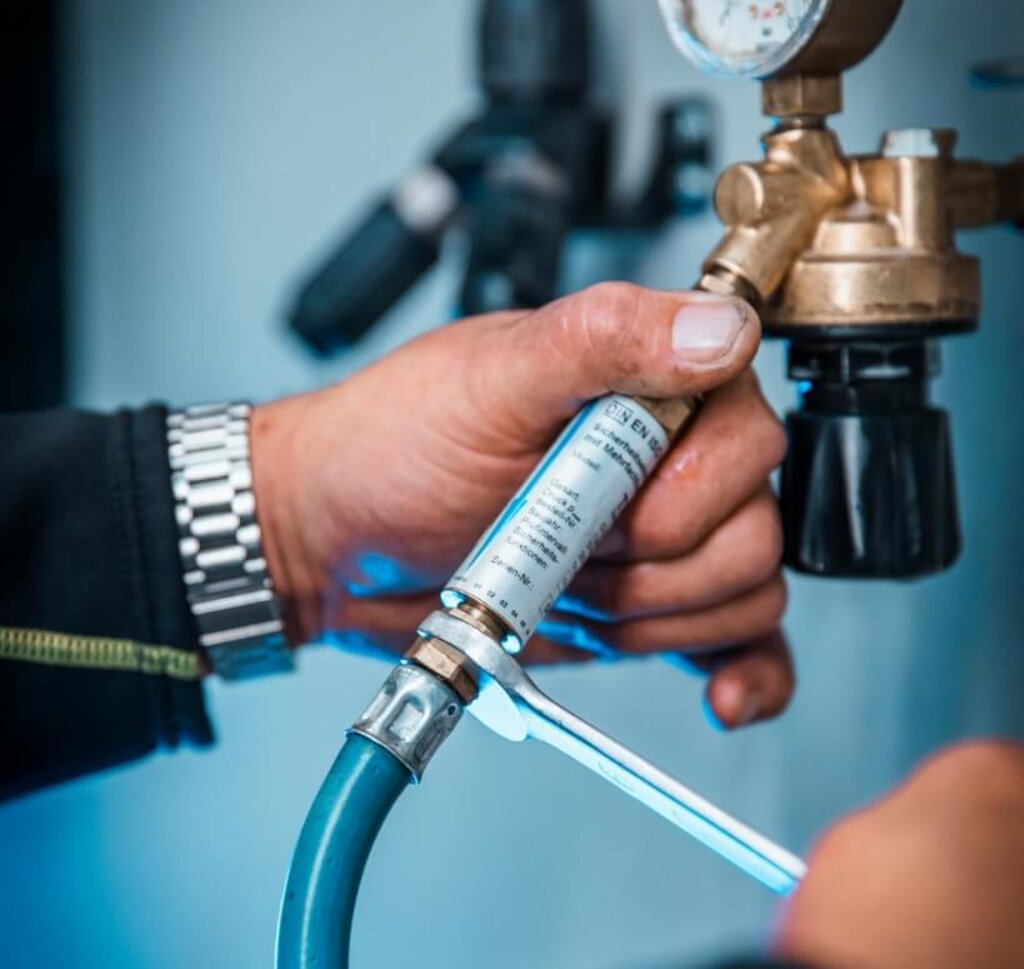 Reihe von Manometern und Prüfanschlüssen an einem technischen Gasprüfstand zur Kontrolle von Druck und Sicherheit.